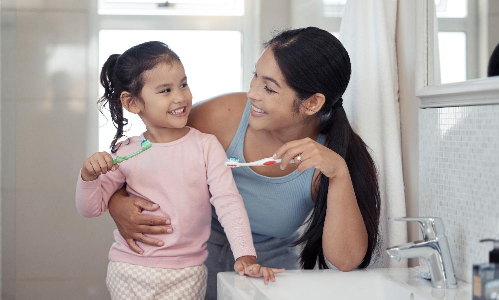 A mother and daughter brushing their teeth