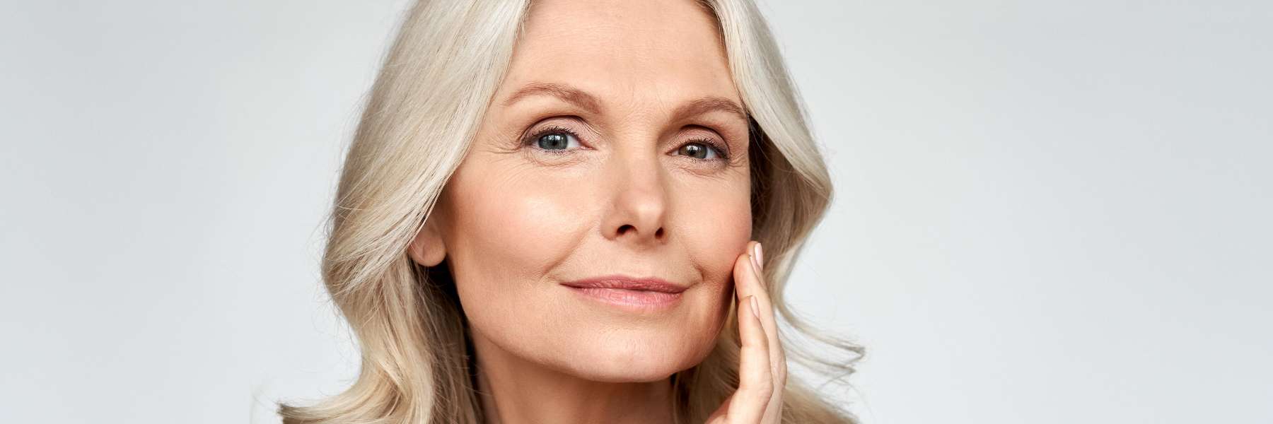 An older woman posing against a white background