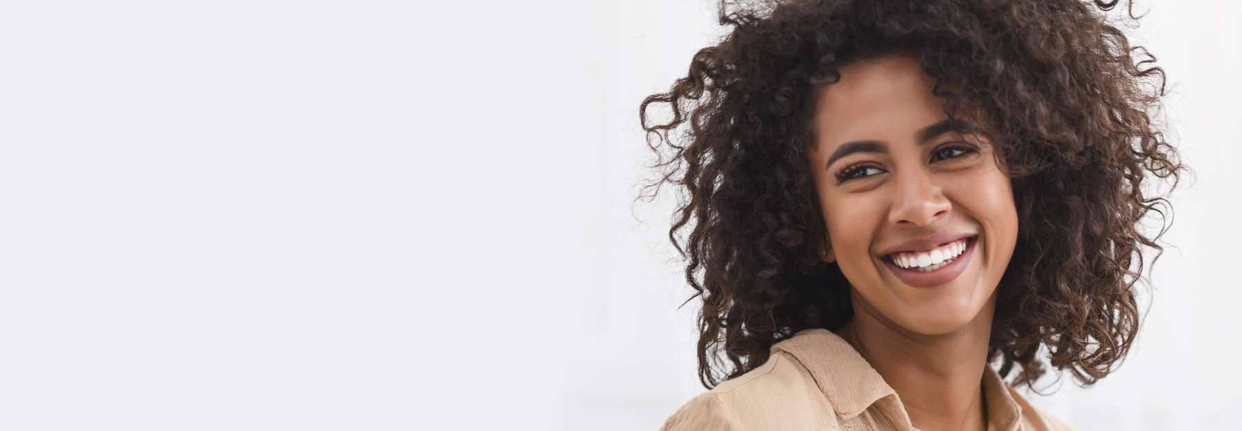 A smiling woman with a white background | full mouth reconstruction Long Beach