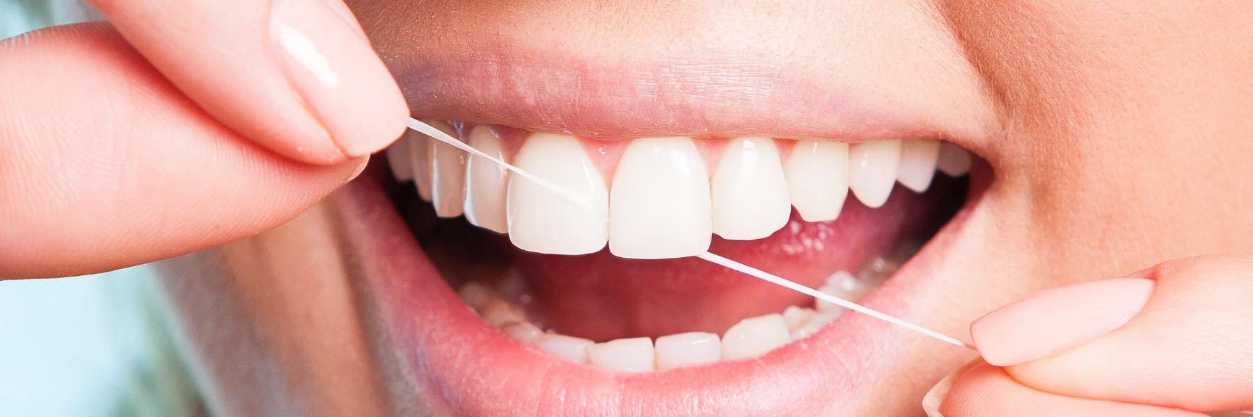 A woman flossing her teeth