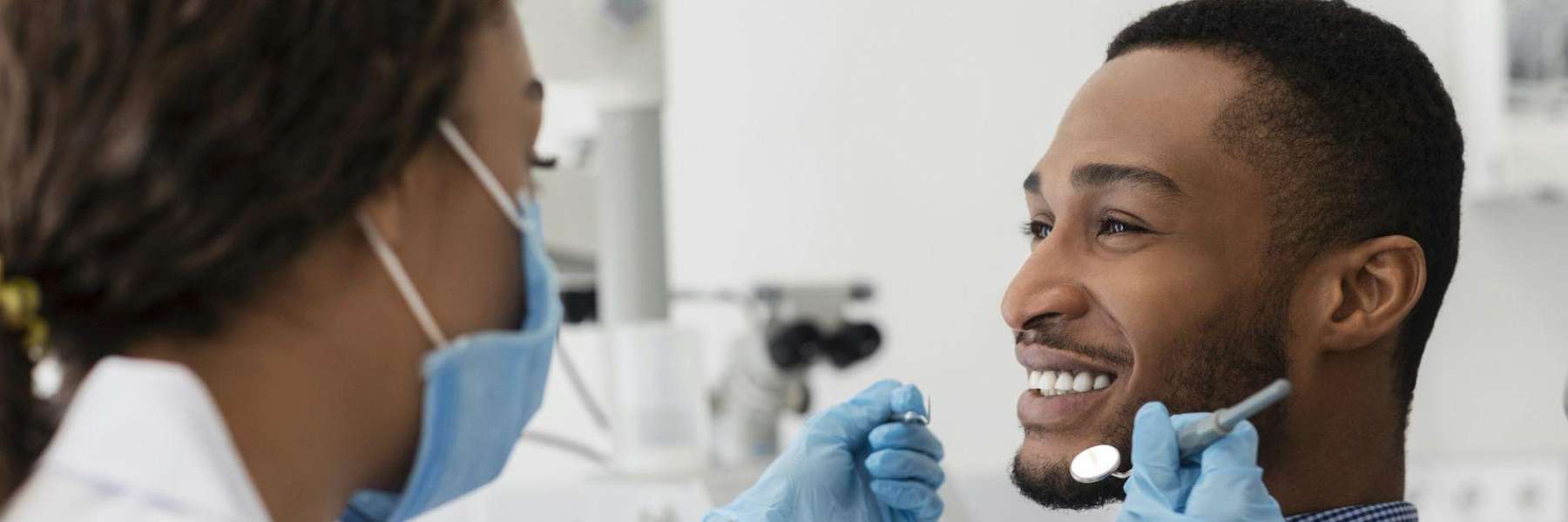 A dentist giving a man an oral examination
