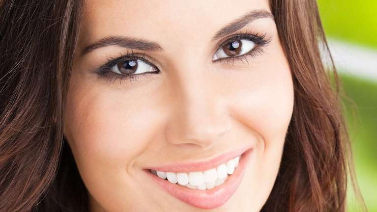 A smiling woman outside | teeth whitening long beach ca