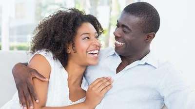 A couple laughing on the couch | Long Beach dentist