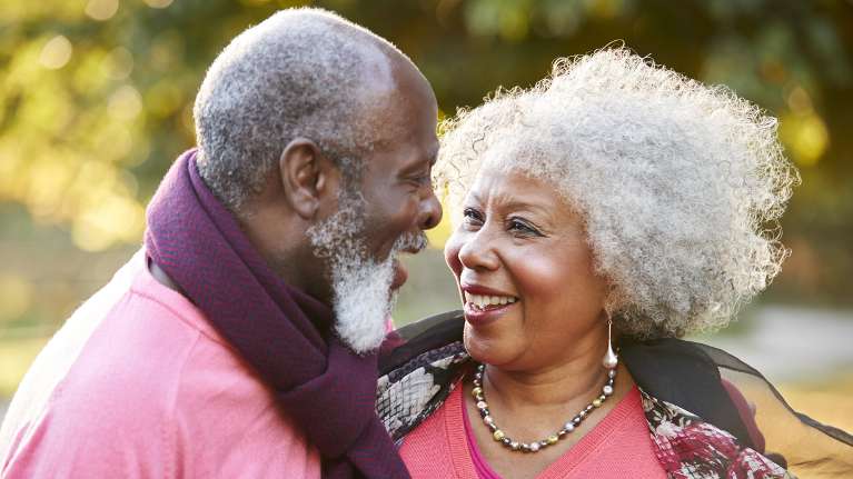 A smiling couple in the park | periodontal treatment Long Beach