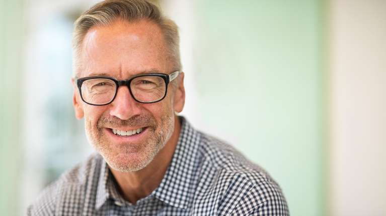 A smiling man with glasses | root canal long beach
