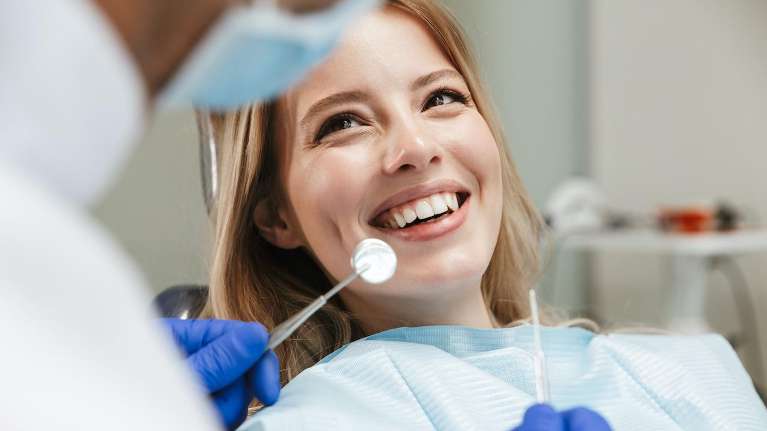 A woman confidently smiles, showcasing teeth whitening benefits.