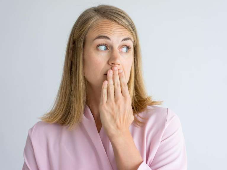 A woman shocked by her bad breath