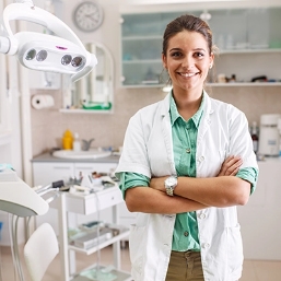 Golden Coast Dental Care smiling doctor in front of dental technology
